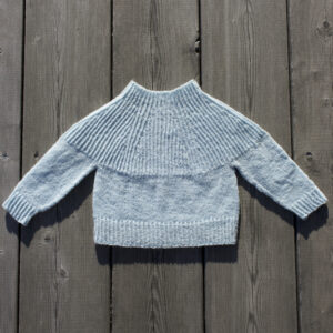 handknitted blue baby sweater on wood floor